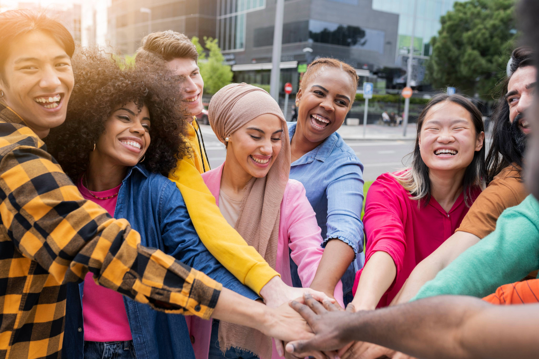 Six people of varying ethnicities standing in a circle